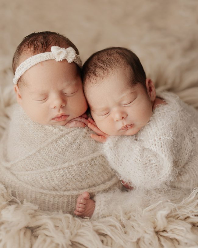 Newborn twins wrapped together in a soft blanket, sleeping peacefully, captured by a Phoenix newborn photographer